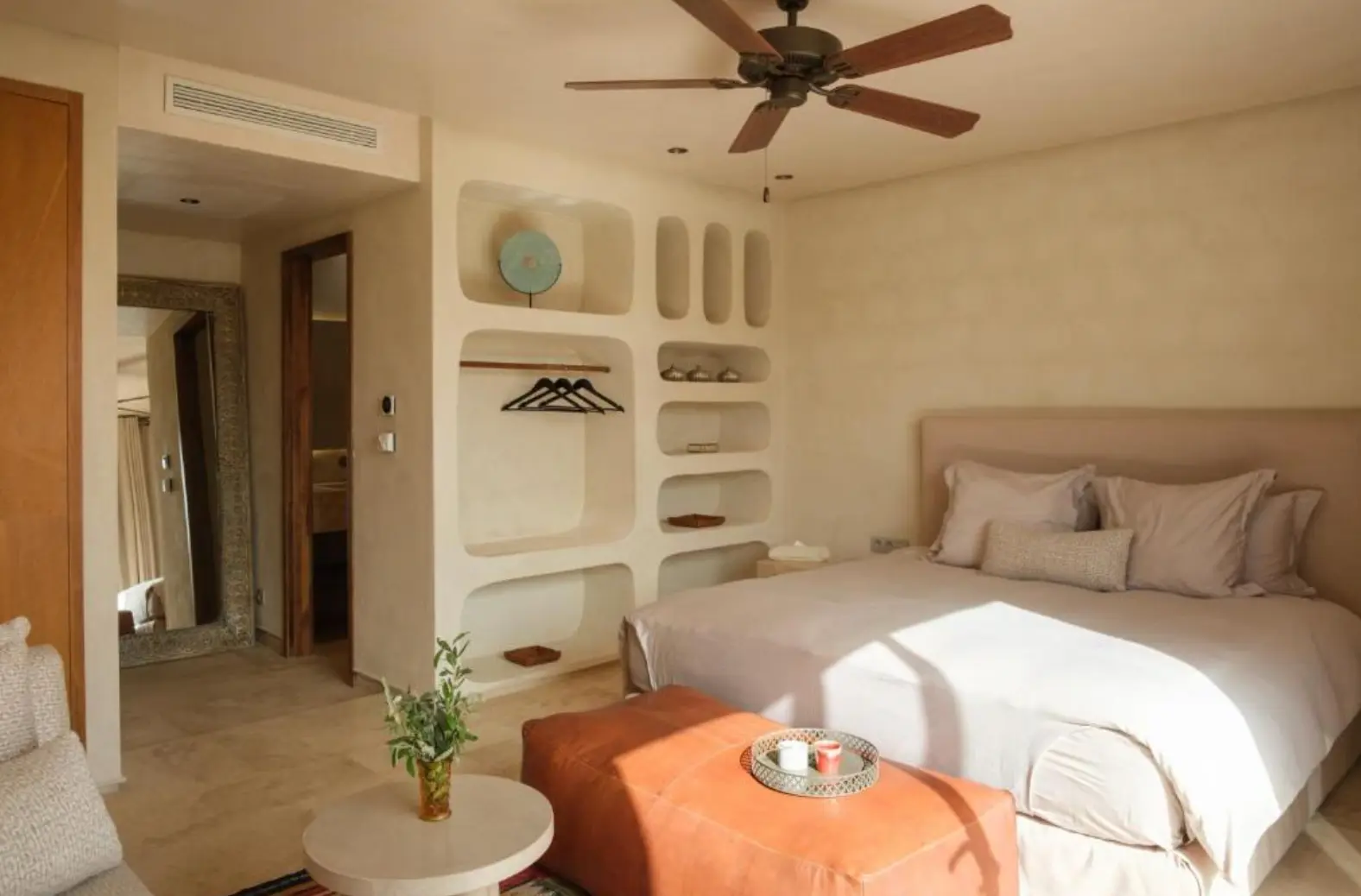 Villa Sama double bedroom with cream walls and a low terracotta ottoman