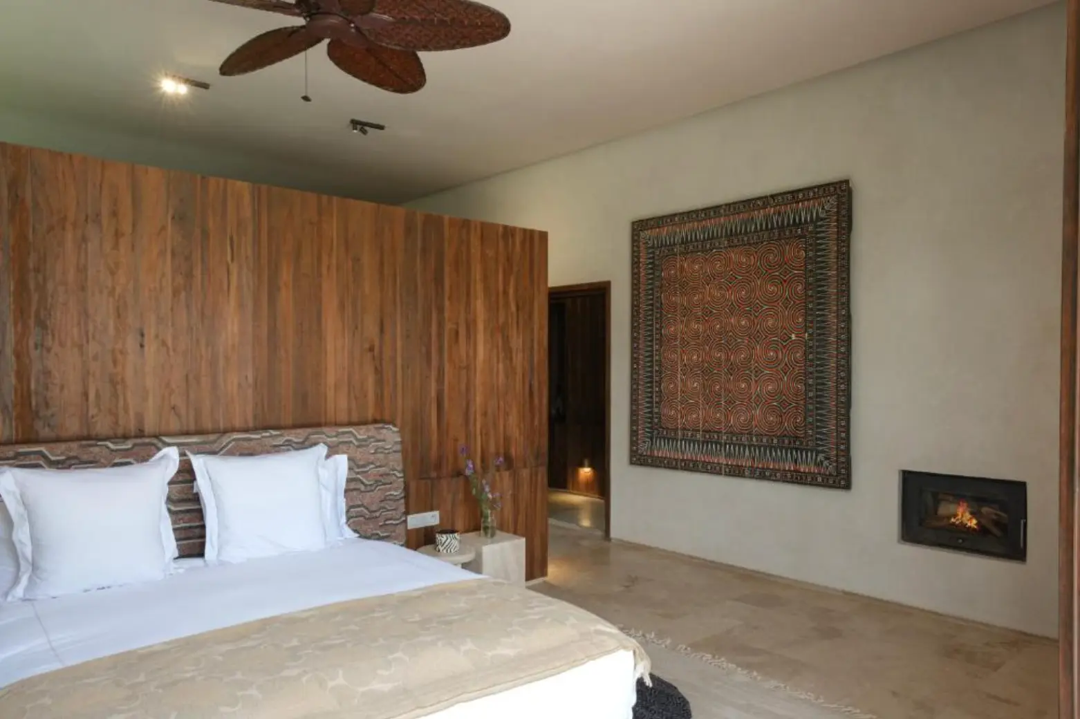 Villa Sama double bedroom with warm wood walls and a fireplace